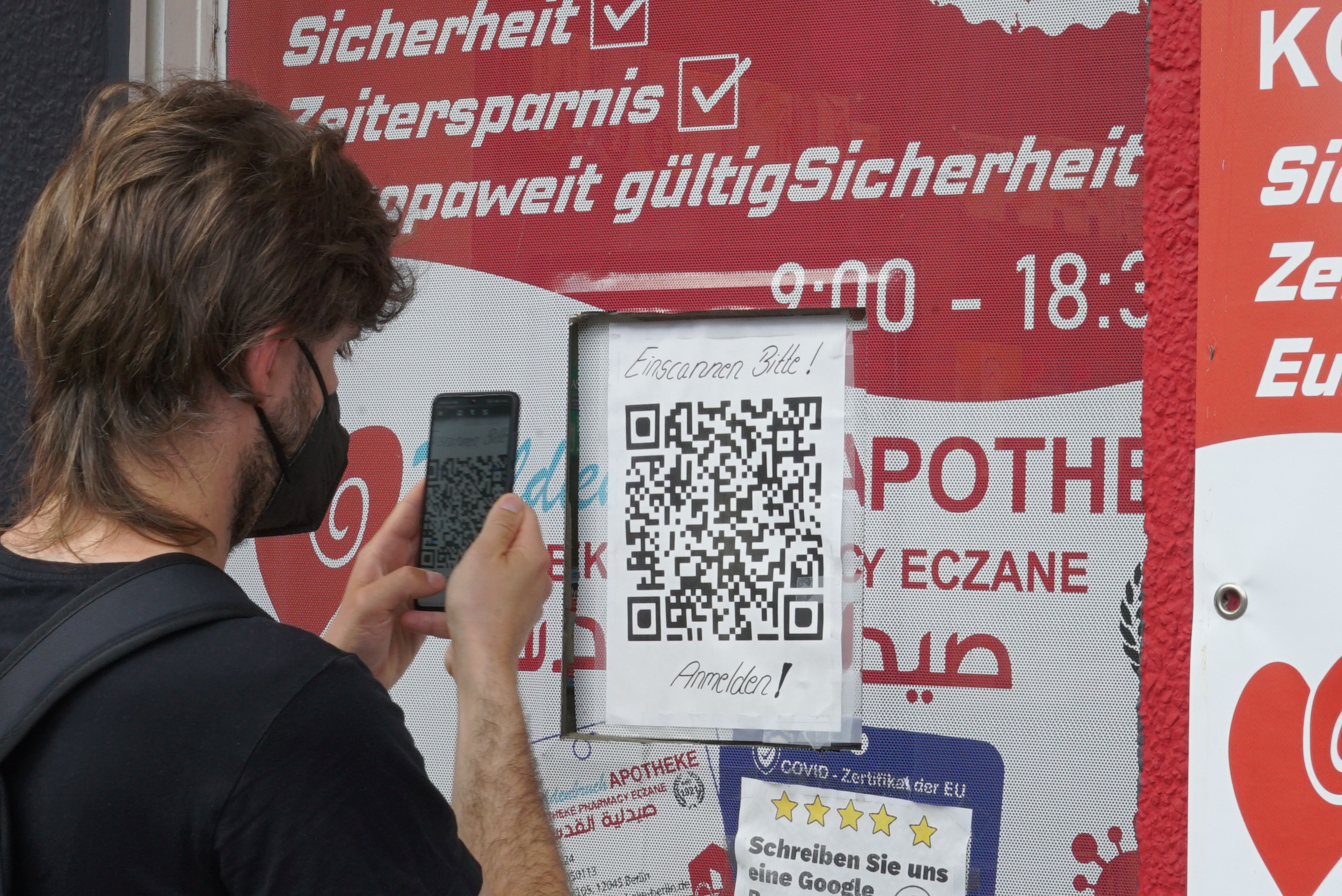 Un muchacho escanea un código QR sobre una ventanita. Serie 'el soporte' de Ibán Ojea