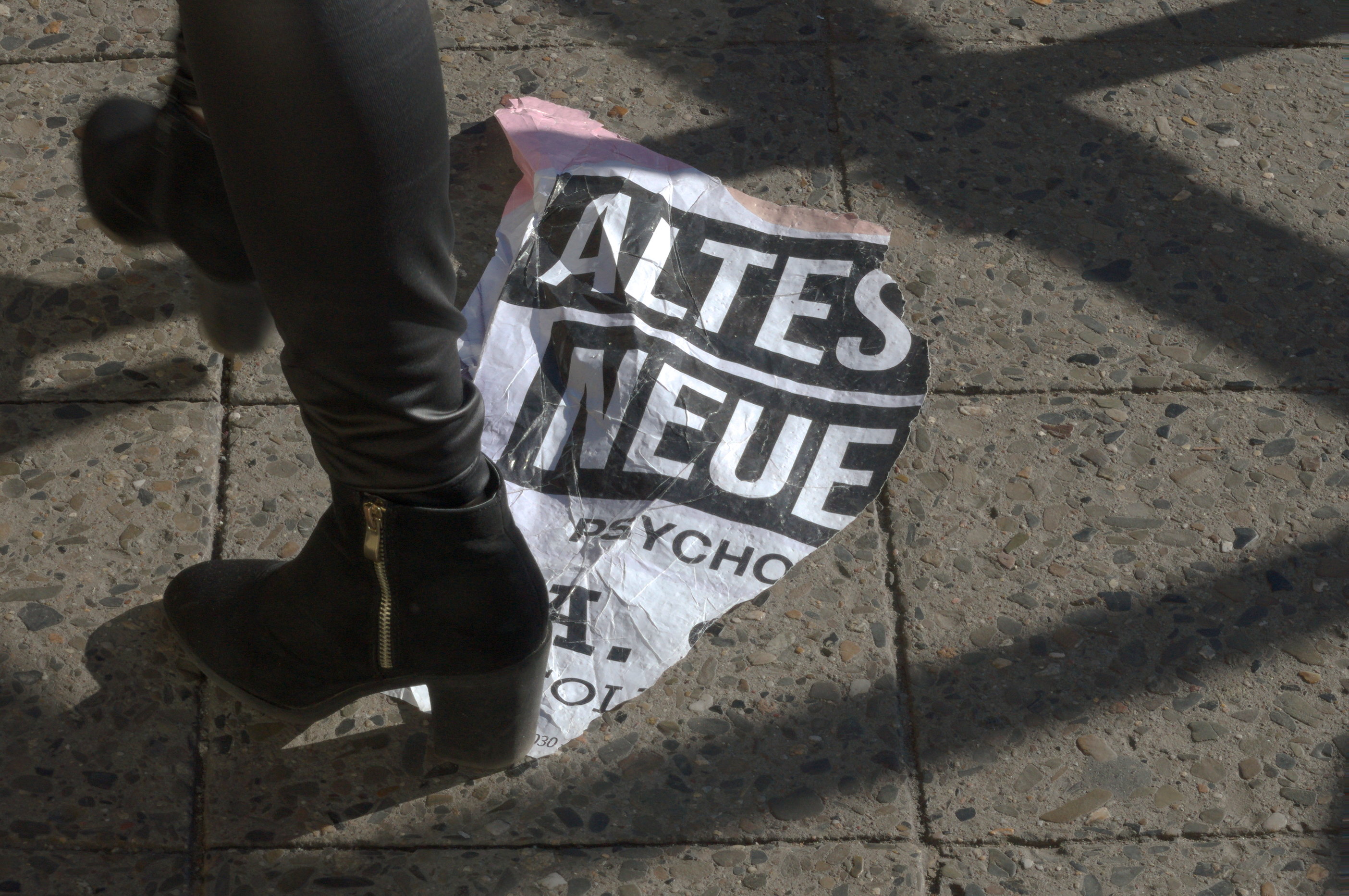Una mujer pisa un fragmento de cartel publicitario. Serie 'el soporte' de Ibán Ojea: exploración de fotografía conceptual en Berlín-Neukölln.