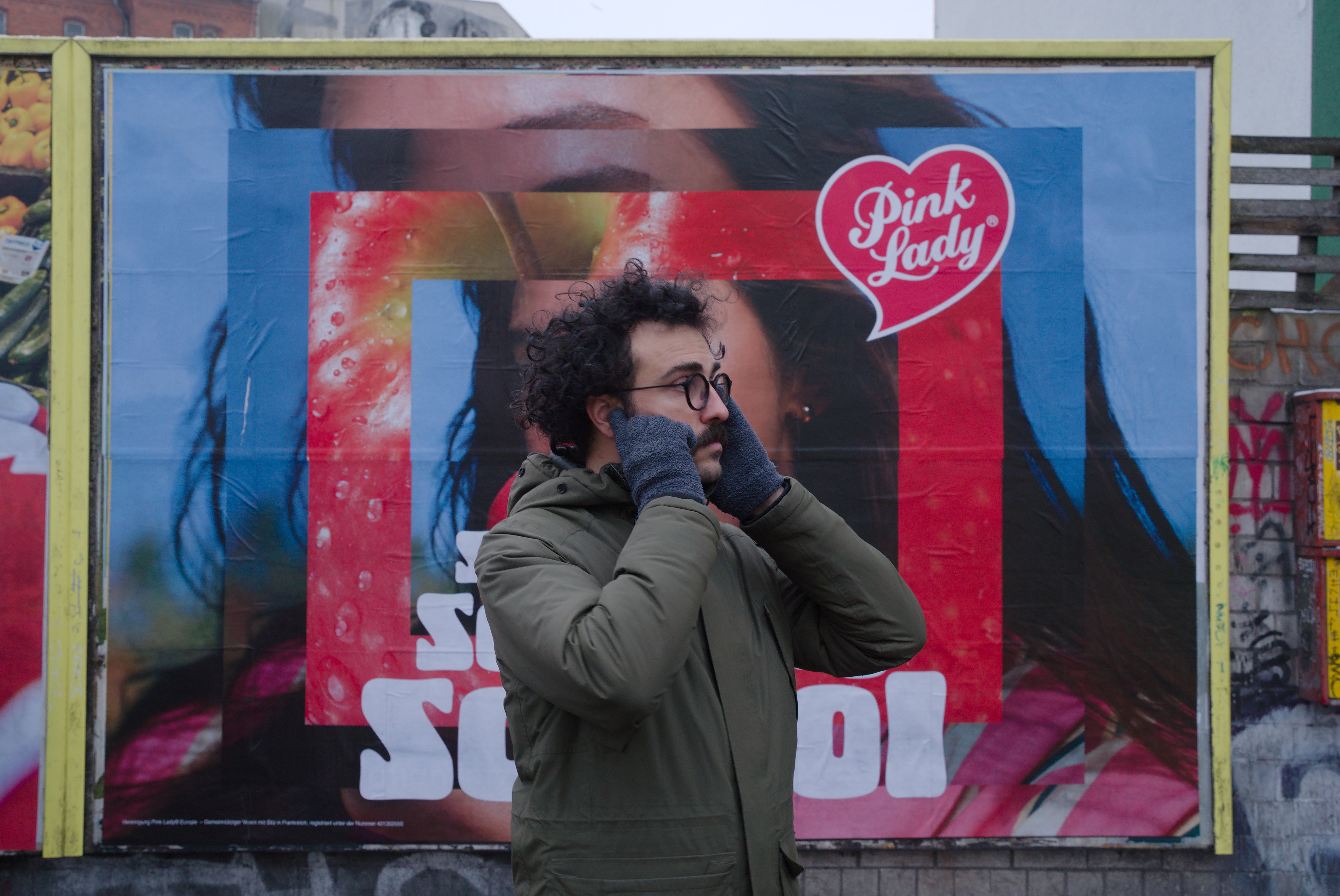 Un hombre se tapa los oídos delante de un cartel. Serie 'el soporte', fotografía de Ibán Ojea.