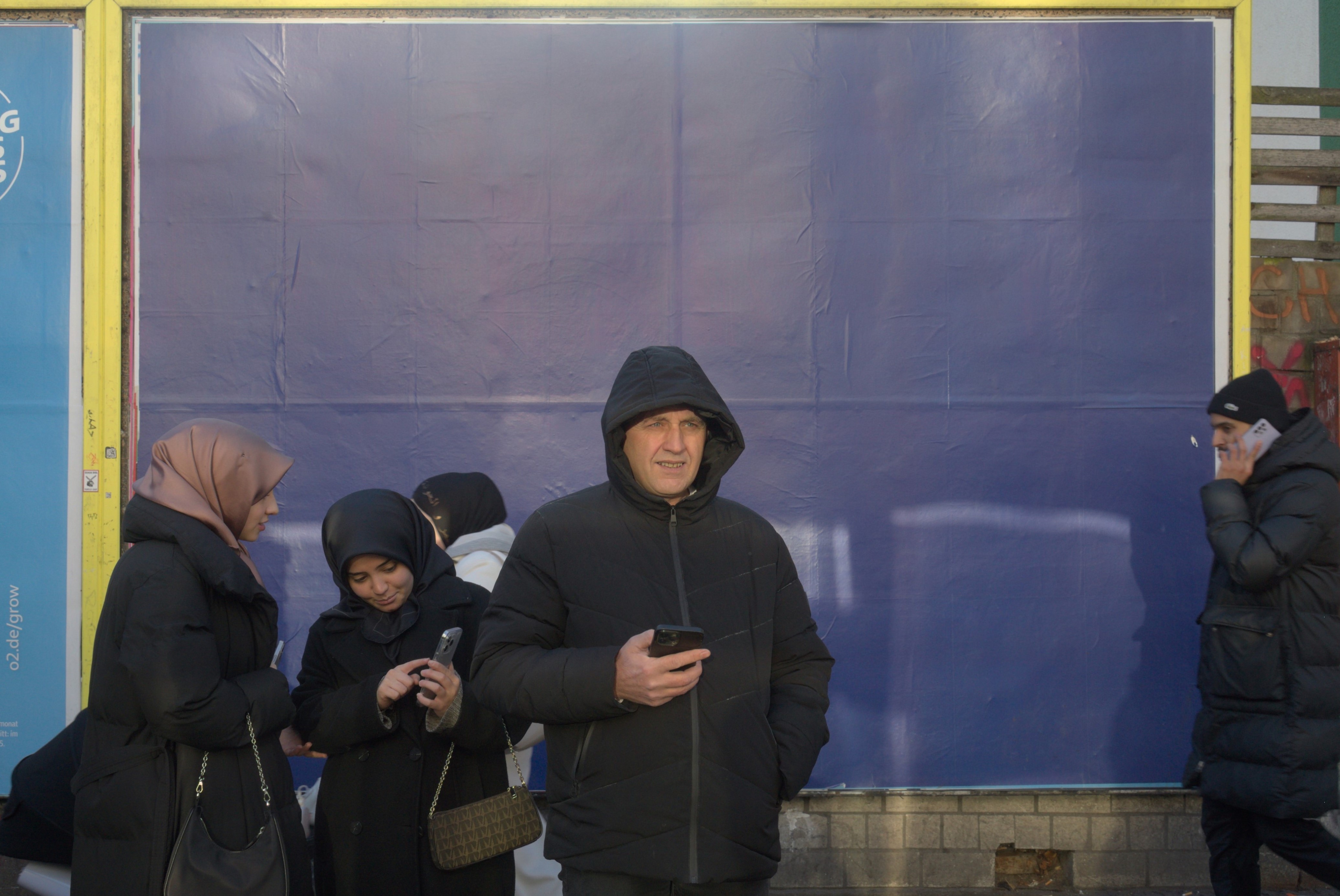 Un hombre mira al horizonte ante un cartel publicitario totalmente azul. Documentalismo subjetivo en Berlín-Neukölln. Serie 'el soporte', fotografía de Ibán Ojea.