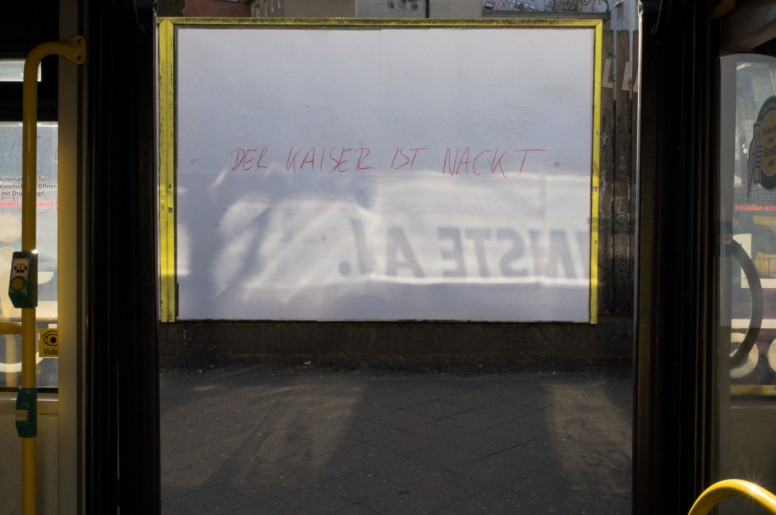 Alguien ha escrito 'Der Kaiser ist nackt' en un cartel publicitario en blanco. Berlín. Serie 'el soporte' de Ibán Ojea.