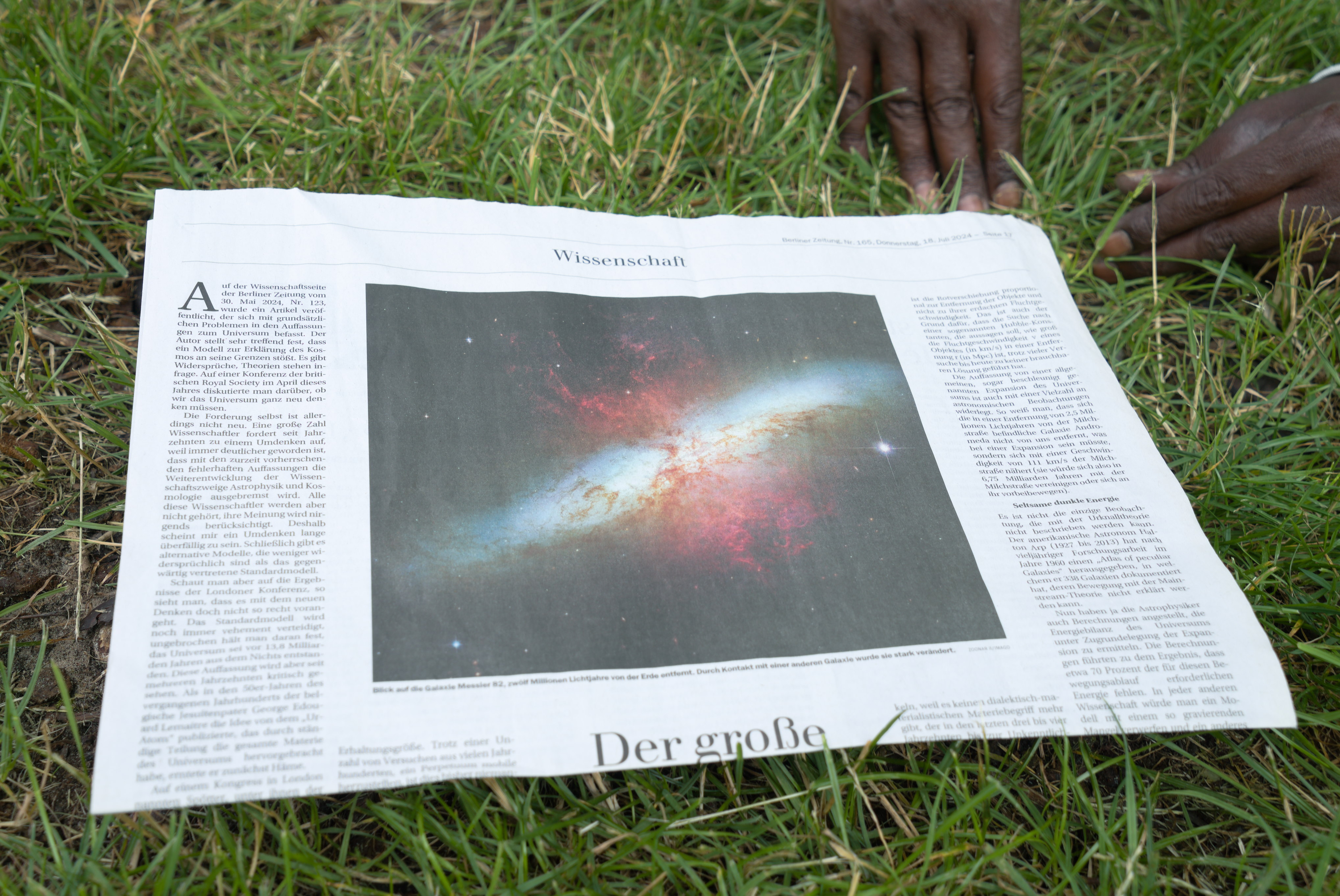 Foto de una galaxia en un periódico sobre el cesped. Obra de la serie 'el soporte' por Ibán Ojea.