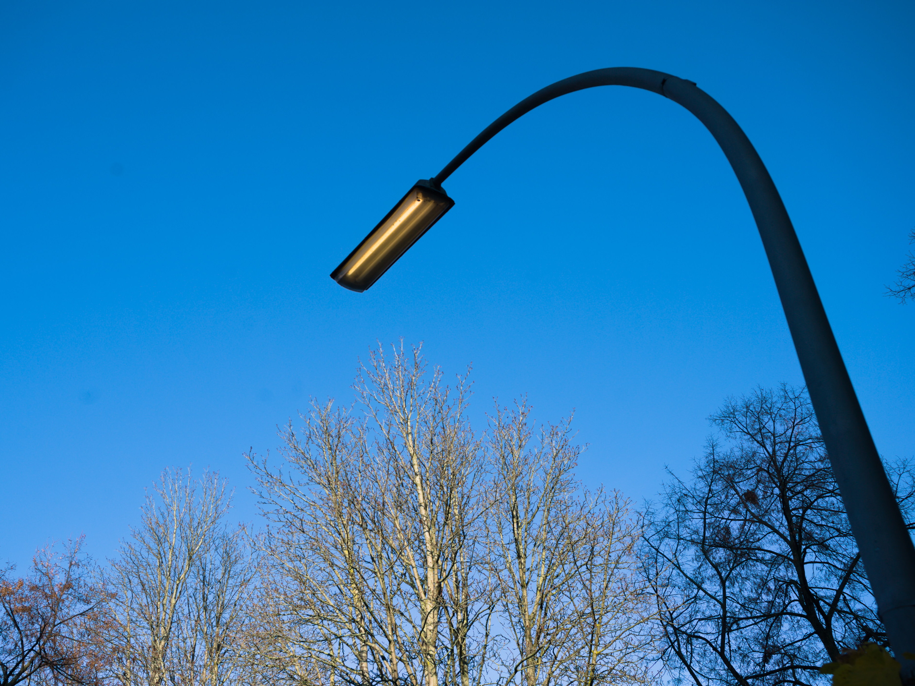 Una farola ilumina a plena luz de un día de invierno. Serie 'el soporte' de Ibán Ojea: fotografía conceptual en Berlín.