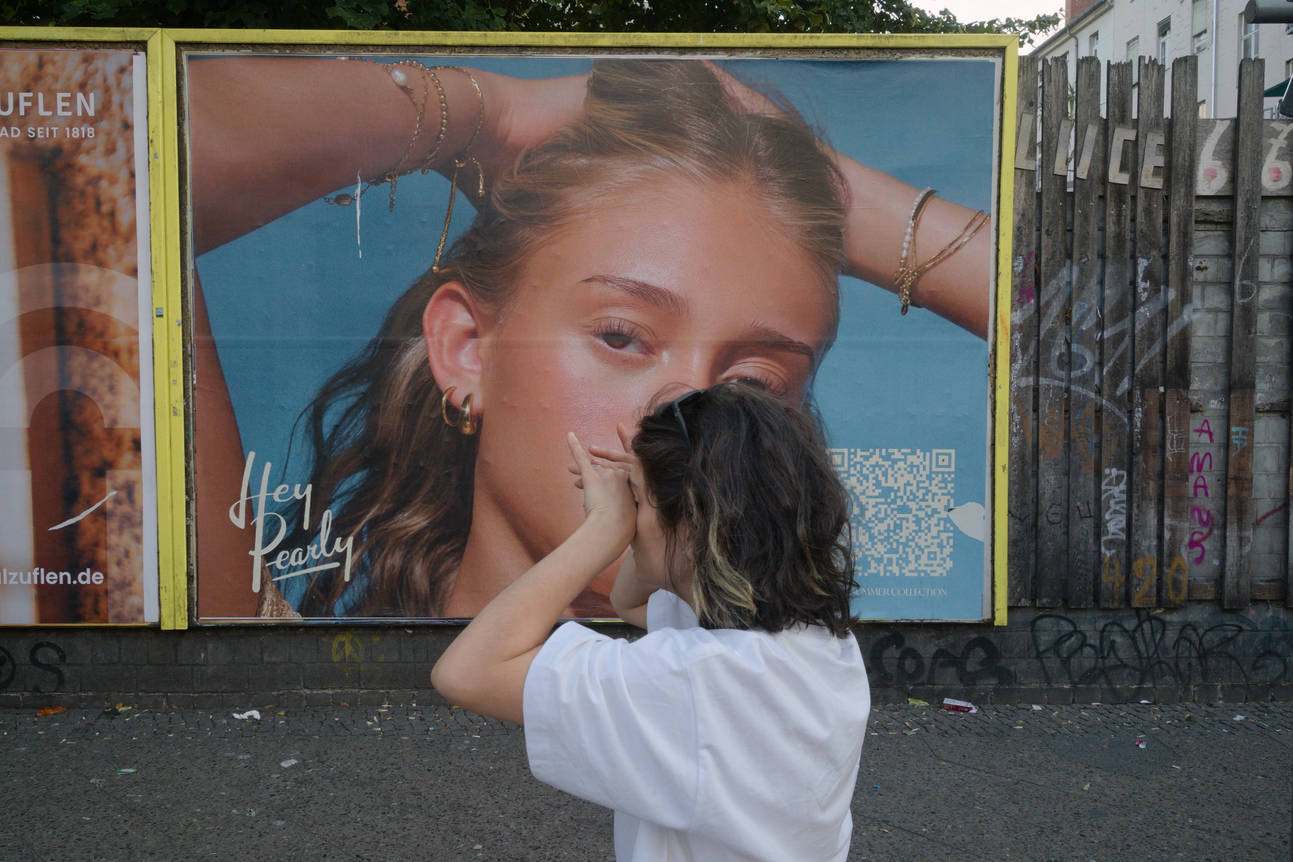 Una chica llorando. Detrás, un cartel publicitario. Serie 'el soporte' de Ibán Ojea.