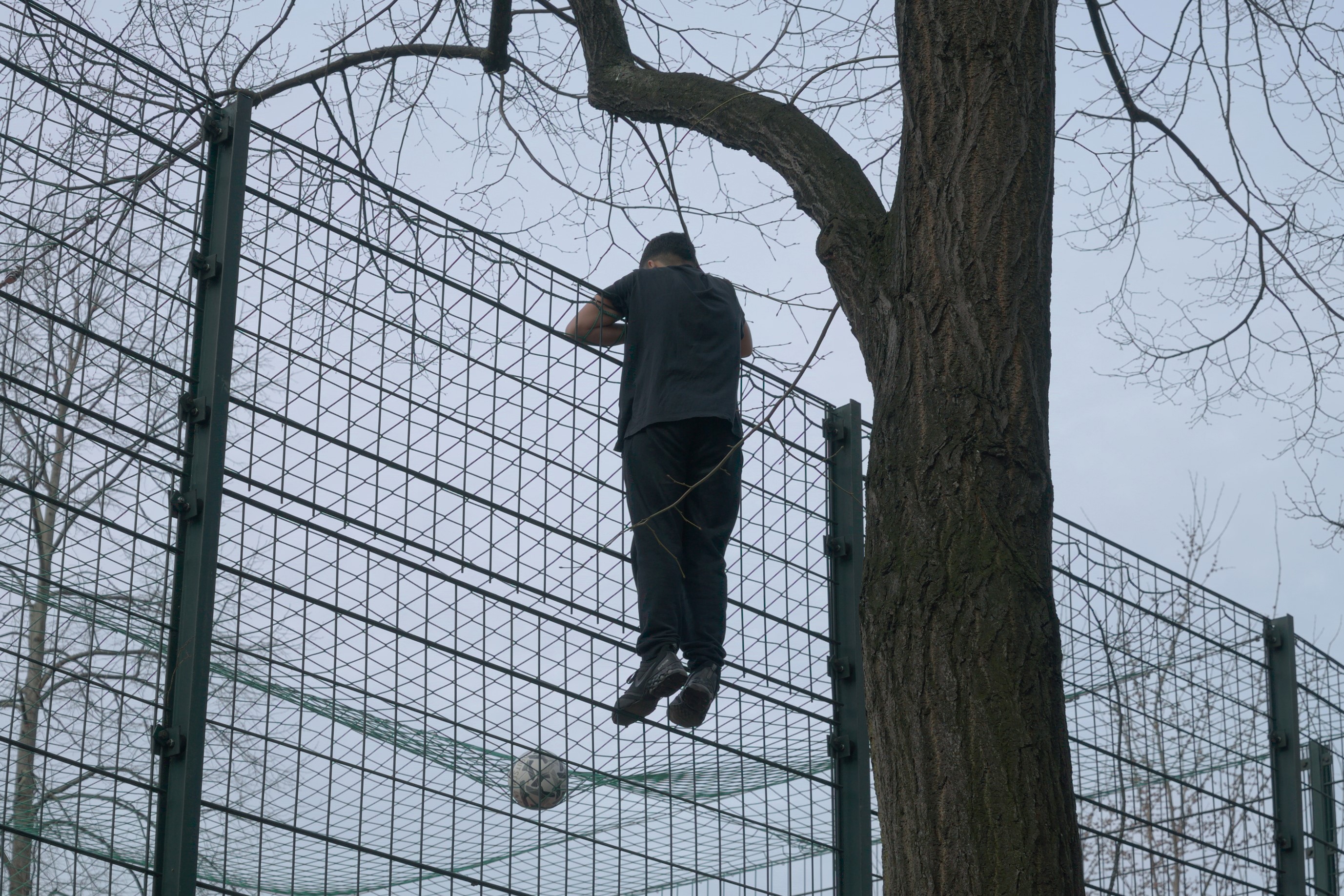 Un niño subido a una estructura ve como no puede recuperar su pelota. Berlín. Serie 'el soporte' de Ibán Ojea.