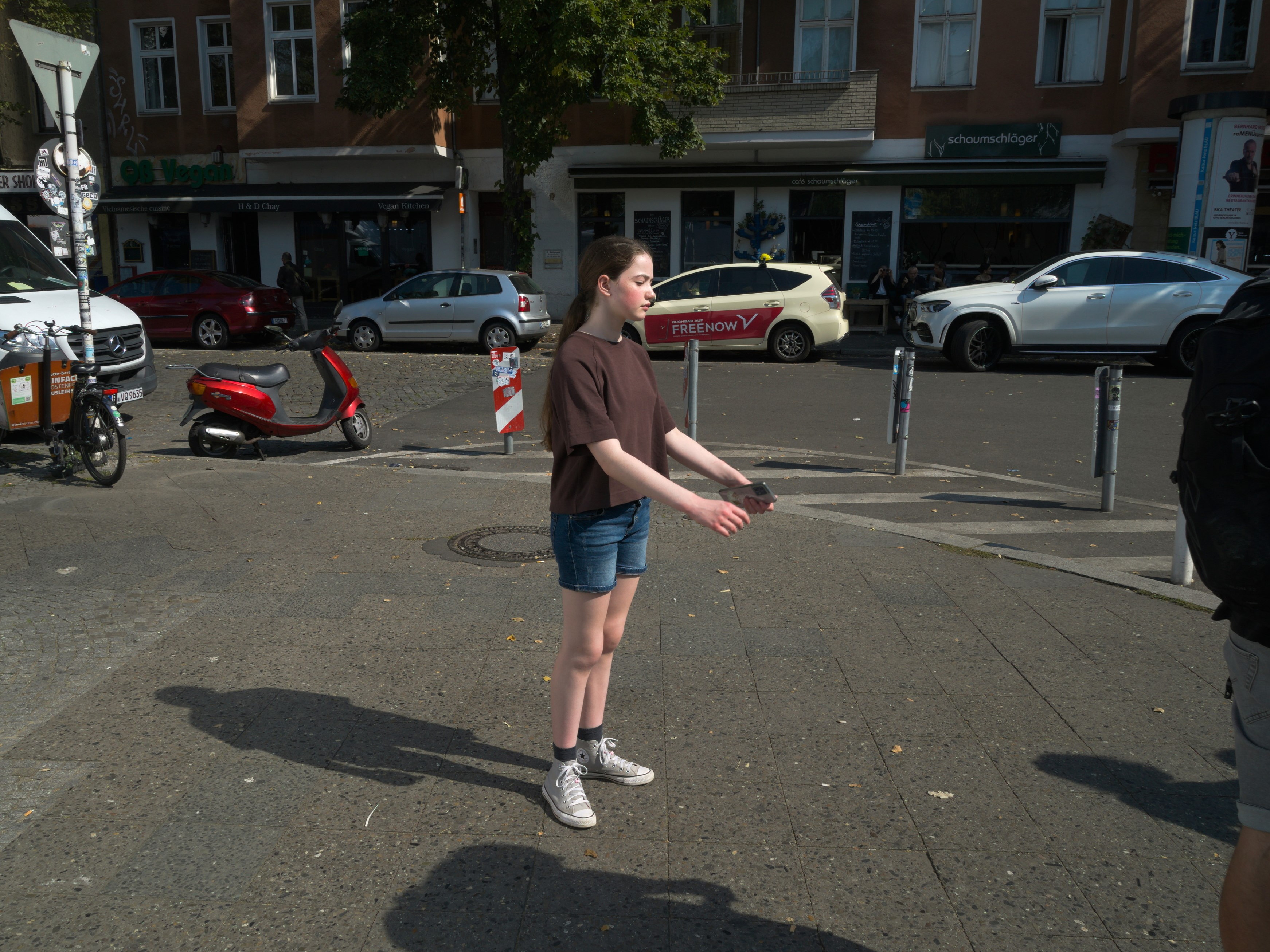 Niña con ojos cerrados a brazos extendidos expuesta al sol. Documentalismo subjetivo en Berlín-Neukölln. Serie 'el soporte', fotografía de Ibán Ojea.